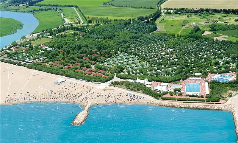 Aerial view of a beach resort with people. Beach, forest, and sea present at Isamar