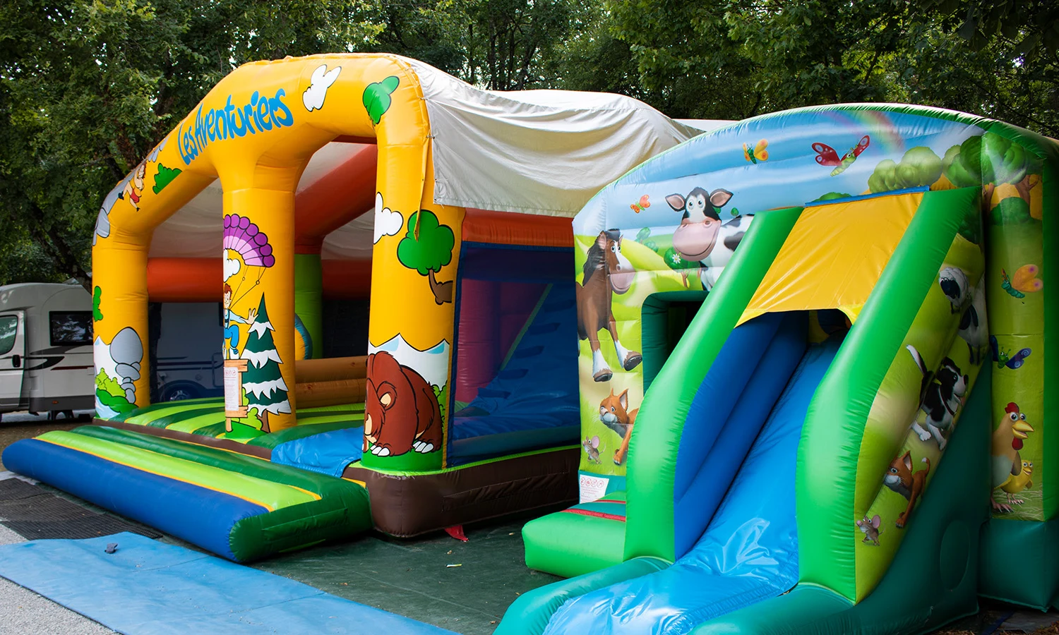 Colorful inflatable bouncy castle and slide under trees at Ardeche Camping 