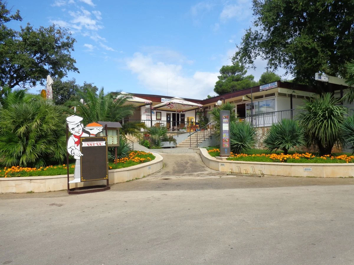 Building with stairs and lush garden, featuring a chef signboard at the entrance at Zelena Laguna