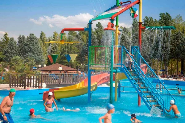 Children playing in a colorful water playground with slides and fountains at Centro Vacanze Verde Azzurro