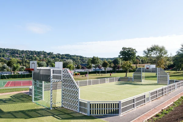 Multi-sport court in use, located in a green, hilly landscape surrounded by fields and trees at Marvilla Parks La Vallée