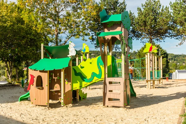Children's playground equipment standing on sandy ground, surrounded by trees and open sky at Marvilla Parks La Vallée