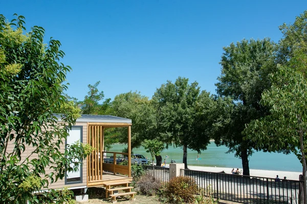 Cabin by lake facing trees and people swimming at de la Bonde