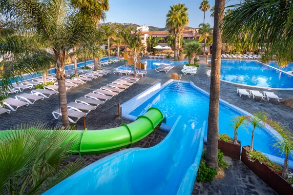 Pools with water slides sit amid sunloungers and palm trees at Enmar