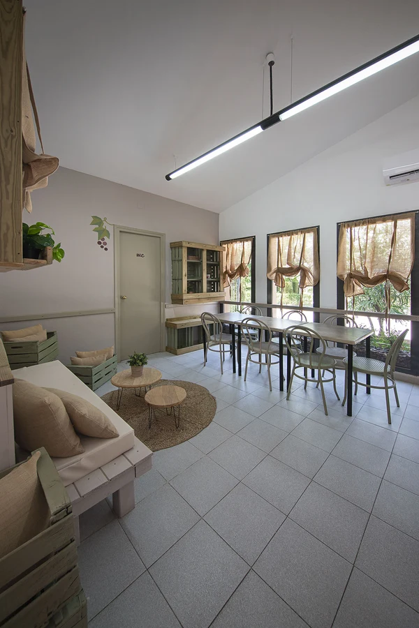 Seating area: Table and chairs before windows, with sofa and small tables nearby, indoors at at Els Ports