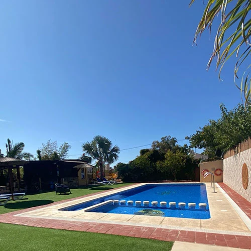 Swimming pool with stepping stones surrounded by lounge chairs and greenery at Armanello