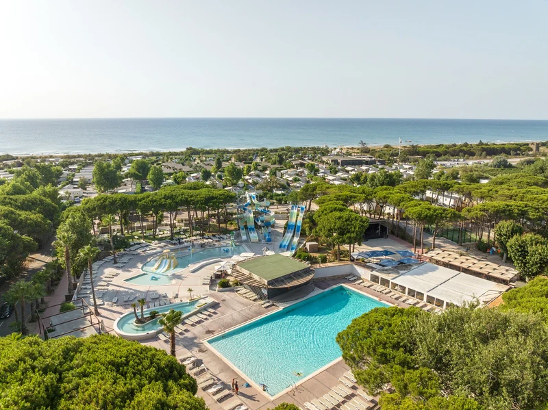 Water park features multiple slides surrounded by trees, near ocean shoreline at Marvilla Parks Le Castellas